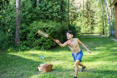 Full length of shirtless boy playing in grass