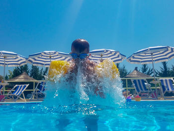 Low angle view of boy swimming in pool 