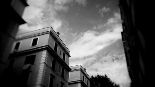Low angle view of buildings against cloudy sky