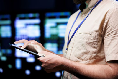 Midsection of man using mobile phone