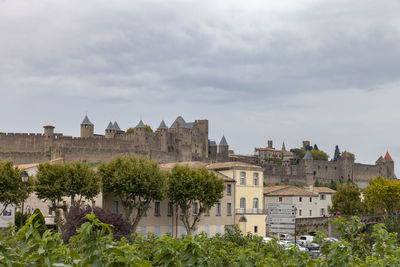 Buildings in city against cloudy sky