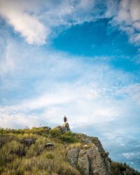 Man on rock against sky