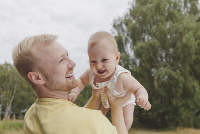 Happy father playing with daughter in park