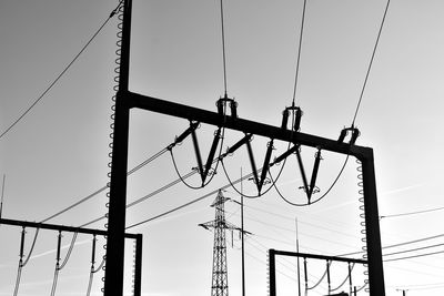 Low angle view of silhouette electricity pylon against sky