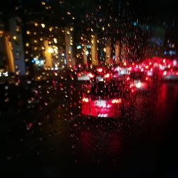 Defocused image of car on illuminated city at night