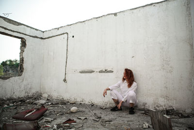 Young woman standing against built structure