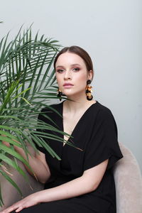 Low angle view of young woman sitting against white background