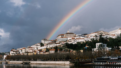 Rainbow over river against sky