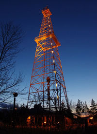 Low angle view of communications tower against sky at night