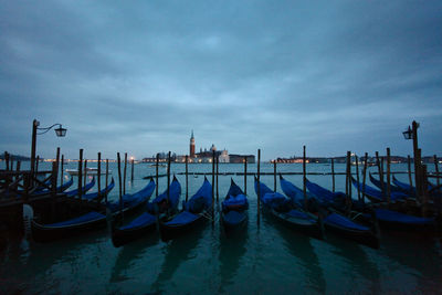 Gondolas on grand canal in city at dusk