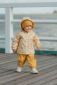 Portrait of boy standing on boardwalk