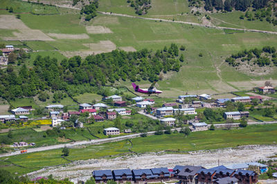 High angle view of trees and houses on field