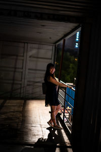 Full length of woman standing by railing