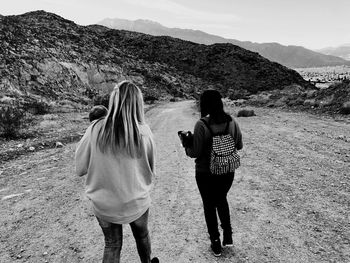 Rear view of female friends walking on mountain