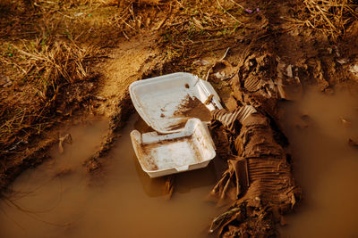 High angle view of damaged abandoned car on land