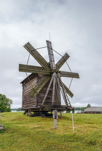 Traditional windmill on field against sky