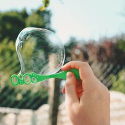 Cropped image of person holding bubbles