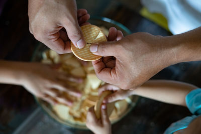 Kids making kek batik or malaysian triple chocolate dessert. crushing the cookies into tiny pieces.