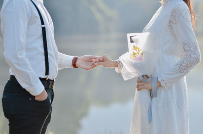 Rear view of couple standing against sky