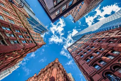 Low angle view of buildings against cloudy sky