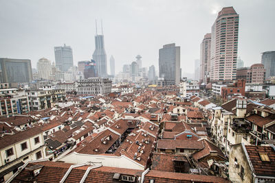 Aerial view of buildings in city against sky