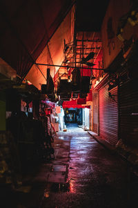 Illuminated street amidst buildings at night