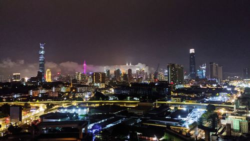 Illuminated buildings in city against sky at night