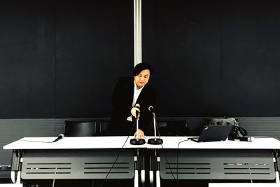 Businessman adjusting microphone in seminar