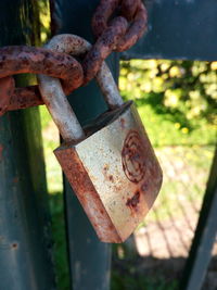 Close-up of padlocks on rusty metal fence