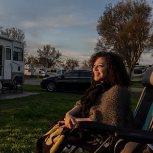 Side view of young woman sitting on field