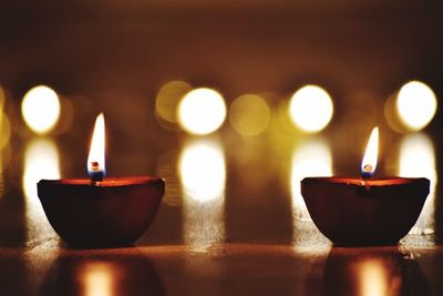 Close-up of illuminated diya on table