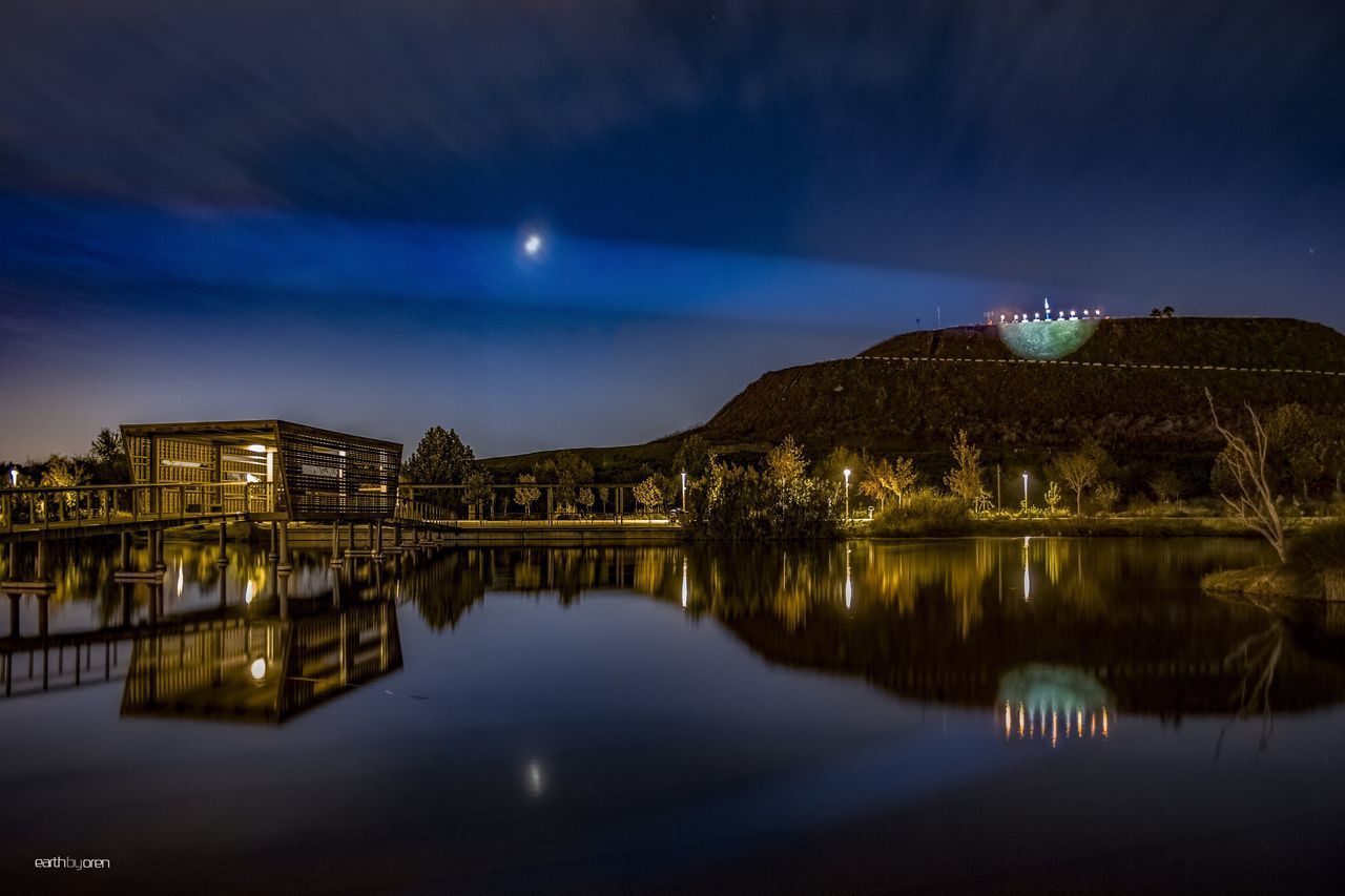 REFLECTION OF ILLUMINATED BUILDINGS IN WATER AT NIGHT