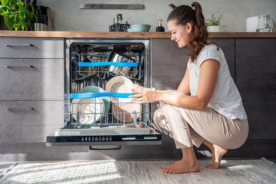 Side view of young woman working at home