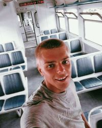 Portrait of smiling man standing in bus