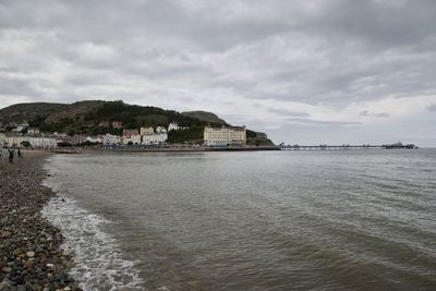 Scenic view of sea by buildings against sky