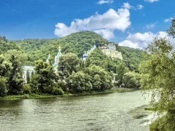Svyatogorsk lavra. scenic view of river by trees against sky