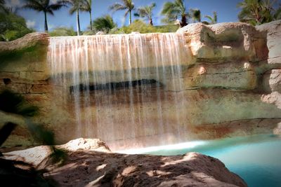 Close-up of rock formation in water against sky