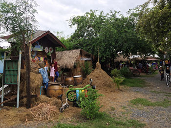 People outside house in village against building