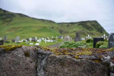 Tilt-shift image of cemetery on mountain against sky
