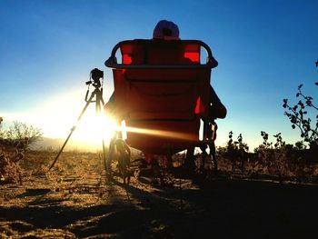 Man on illuminated road against sky during sunset