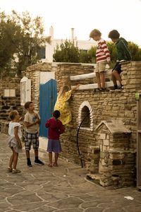 Rear view of siblings standing against trees