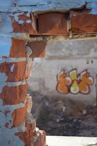 Graffiti seen through broken wall