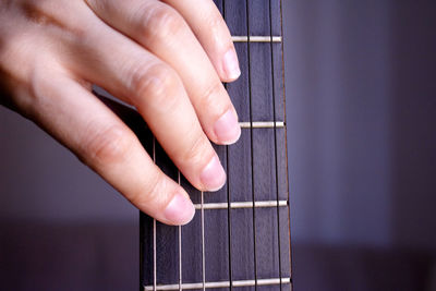 Close-up of hands touching guitar