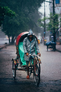 Rear view of man riding motorcycle on street