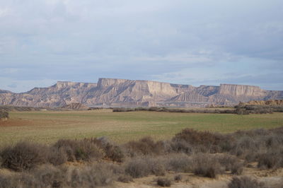 Scenic view of field and mountains against sky