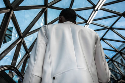 Low angle view of man against window