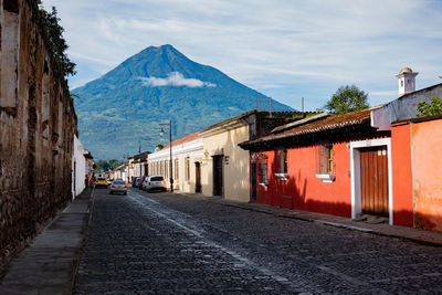 Footpath amidst buildings against sky