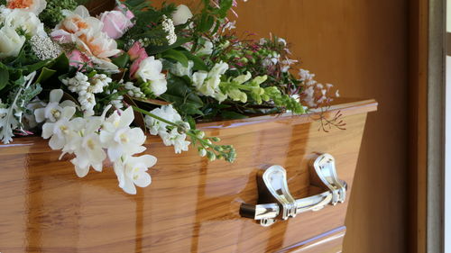 Closeup shot of a funeral casket or coffin in a hearse or chapel or burial at cemetery
