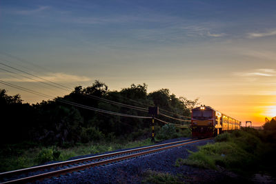 Train on railway tracks against sky during sunset