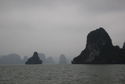 Rock formations in sea against sky